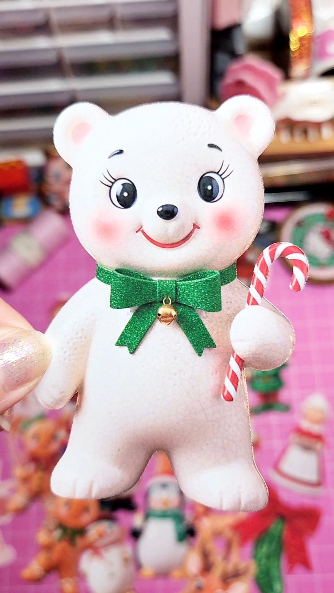 White teddy bear plush toy with a green bow and candy cane on a colorful background