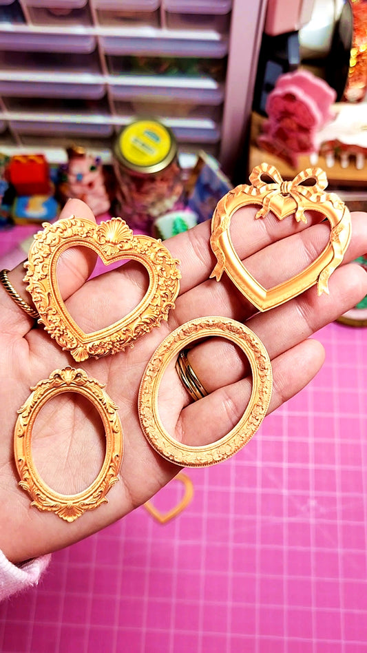 Gold heart-shaped frames held in a hand with a pink grid background