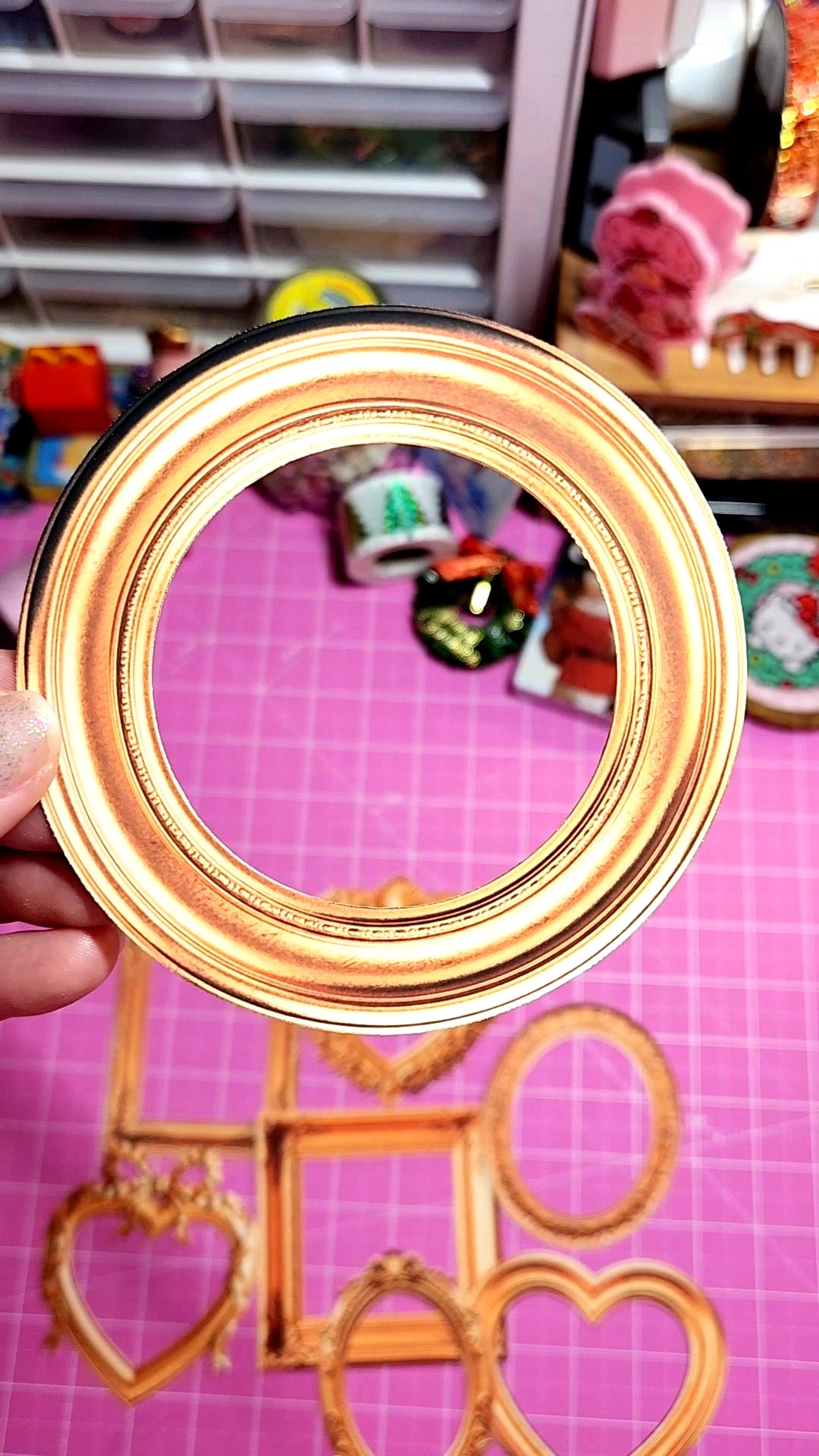 Gold circular object held in front of a colorful background with toys and stationery items.