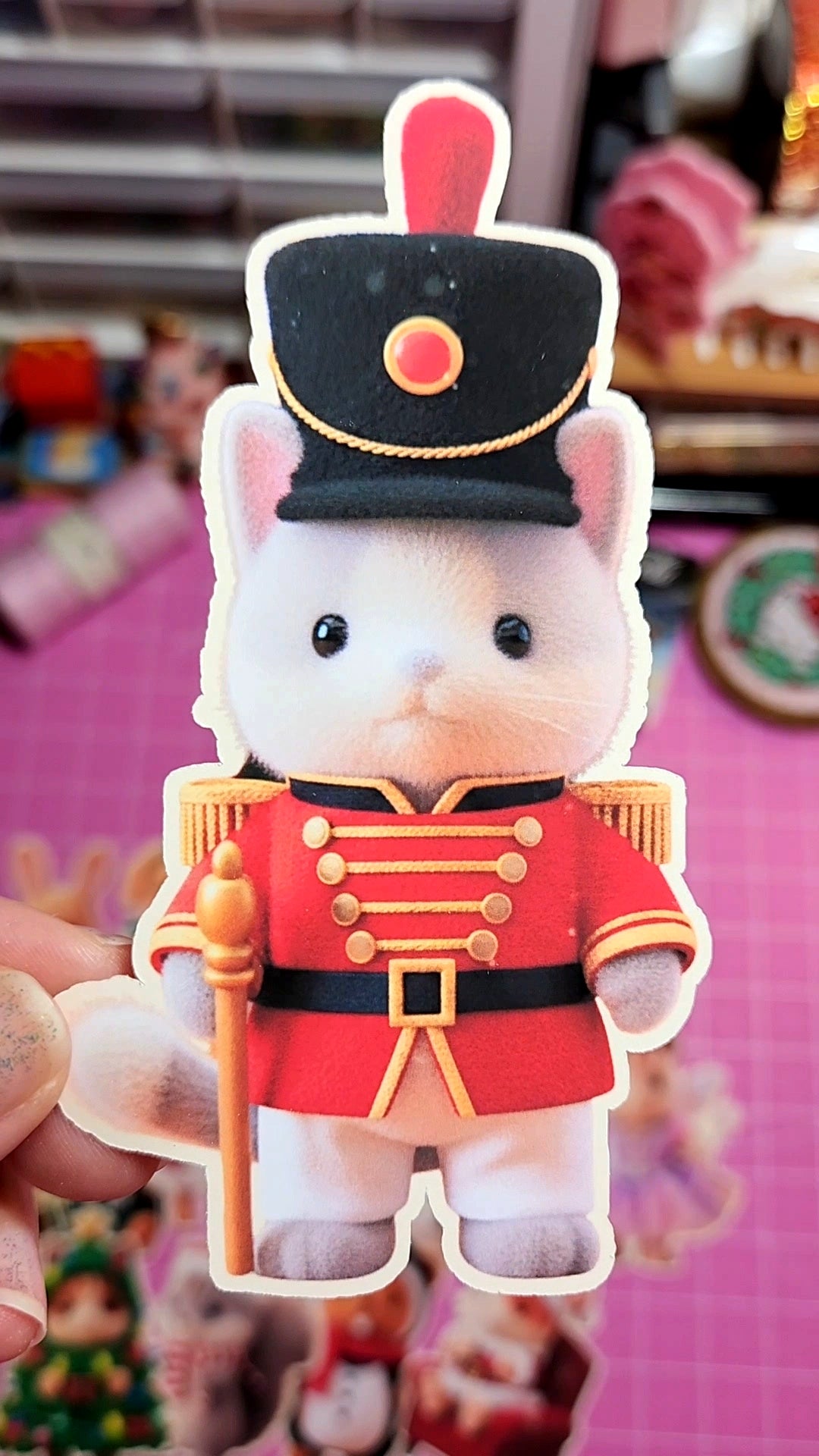 Toy figure of a rabbit in a military uniform held against a blurred background