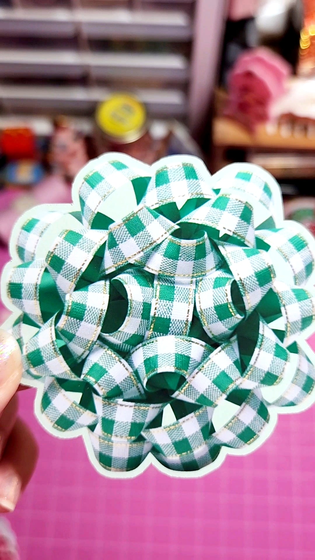 Green and white checkered bow on a pink background