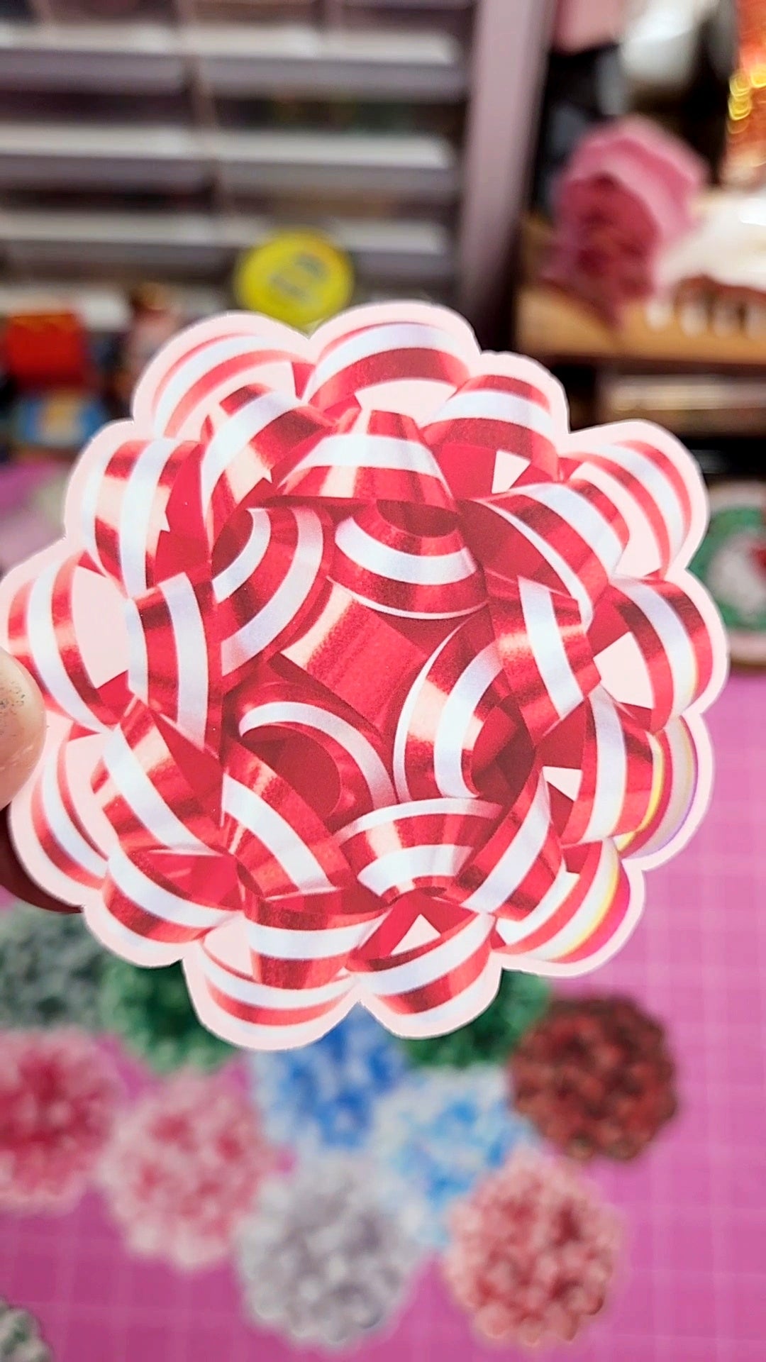 Decorative flower made of red and white striped paper on a colorful background