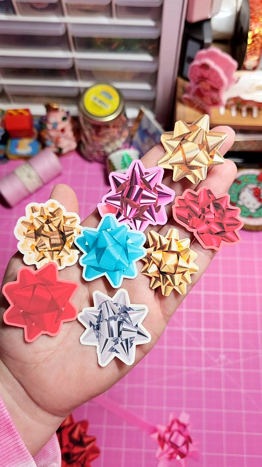 Colorful star-shaped plastic items held in a hand with a pink grid background.