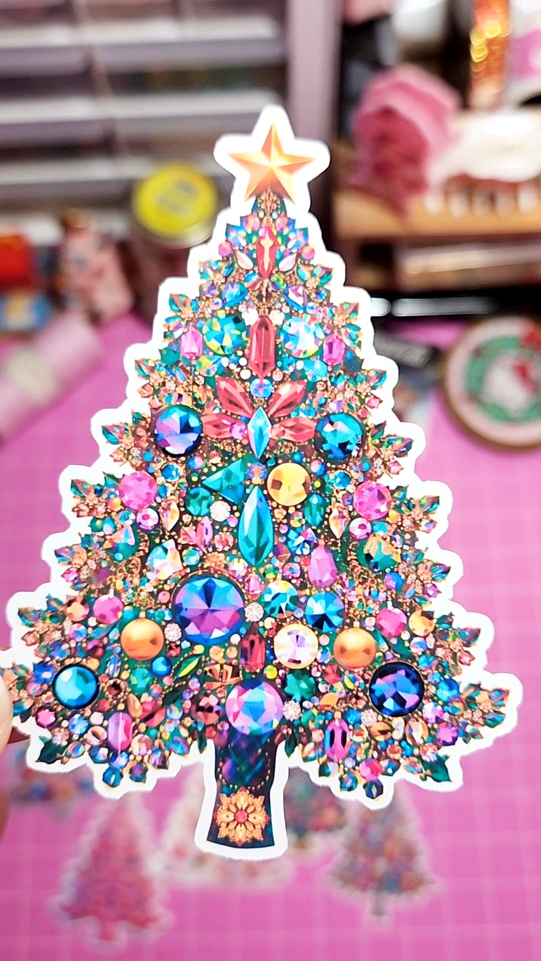 Colorful jeweled Christmas tree decoration on a pink background