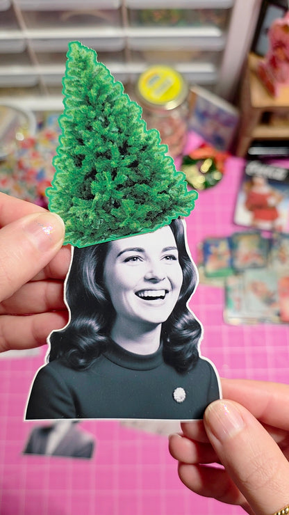 Person holding a cutout with a green tree on top of their head against a colorful background.