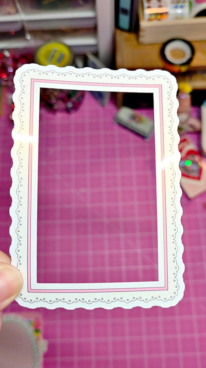 Decorative white frame held over a pink grid background