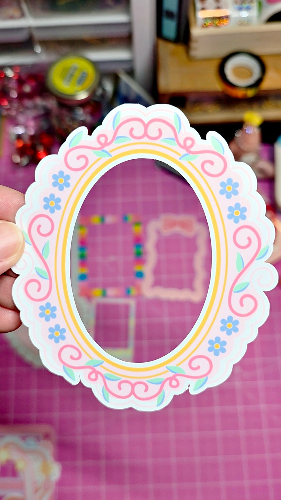 Decorative sticker with floral border held against a colorful background