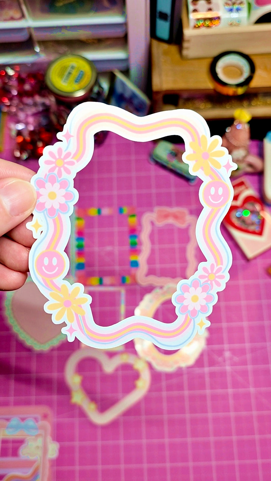 Decorative paper frame with floral designs held over a colorful background