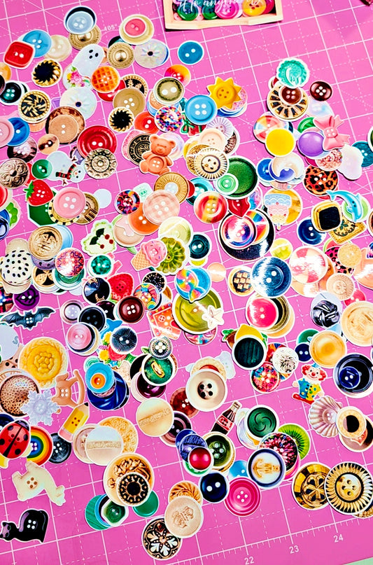 Assorted colorful buttons on a pink grid background