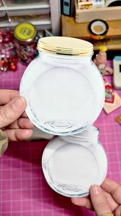 Clear glass jar with gold lid held by a hand on a pink surface.
