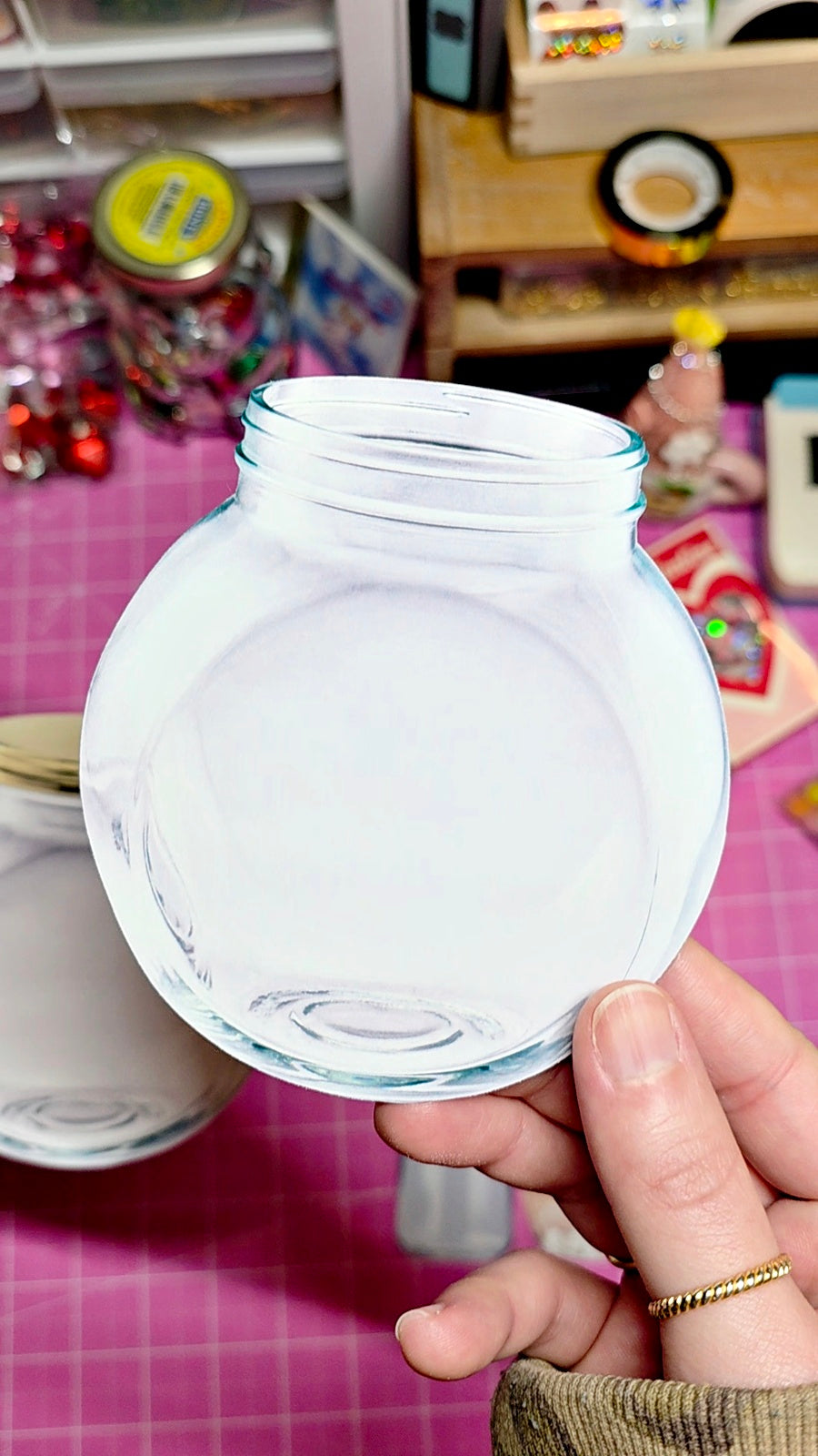 Clear plastic lid held by a hand on a colorful background