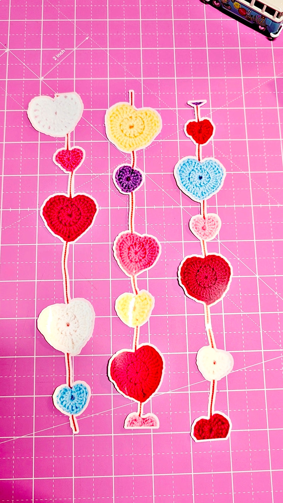 Decorative heart-shaped items on a pink grid background