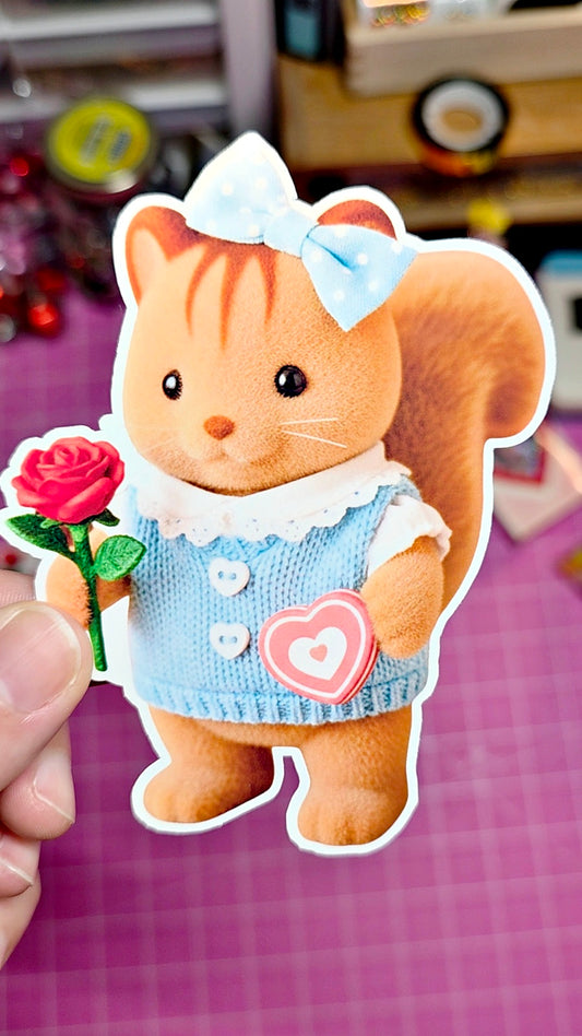 Cartoon cat with a blue bow and dress holding a flower, on a pink checkered background.