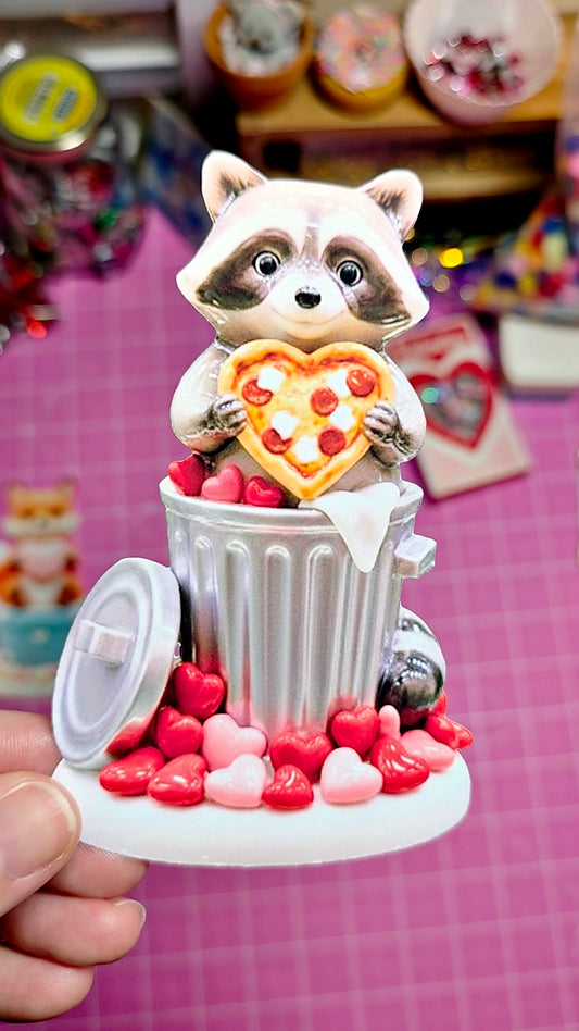 Decorative item with a raccoon holding a heart-shaped pizza in a trash can on a checkered background.