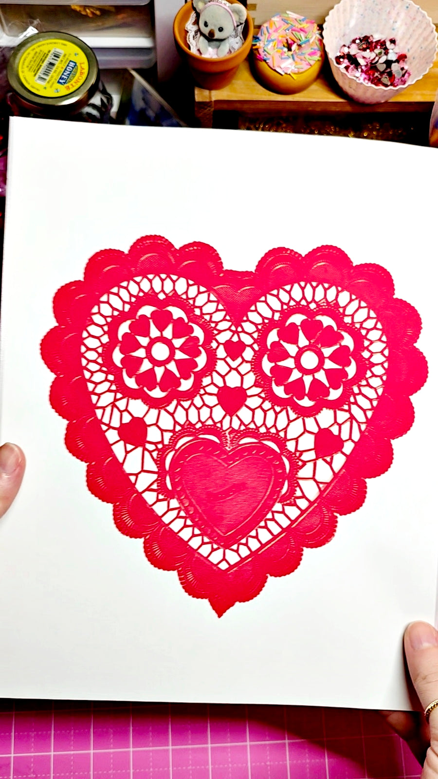 Heart-shaped paper cutout with intricate designs on a white background