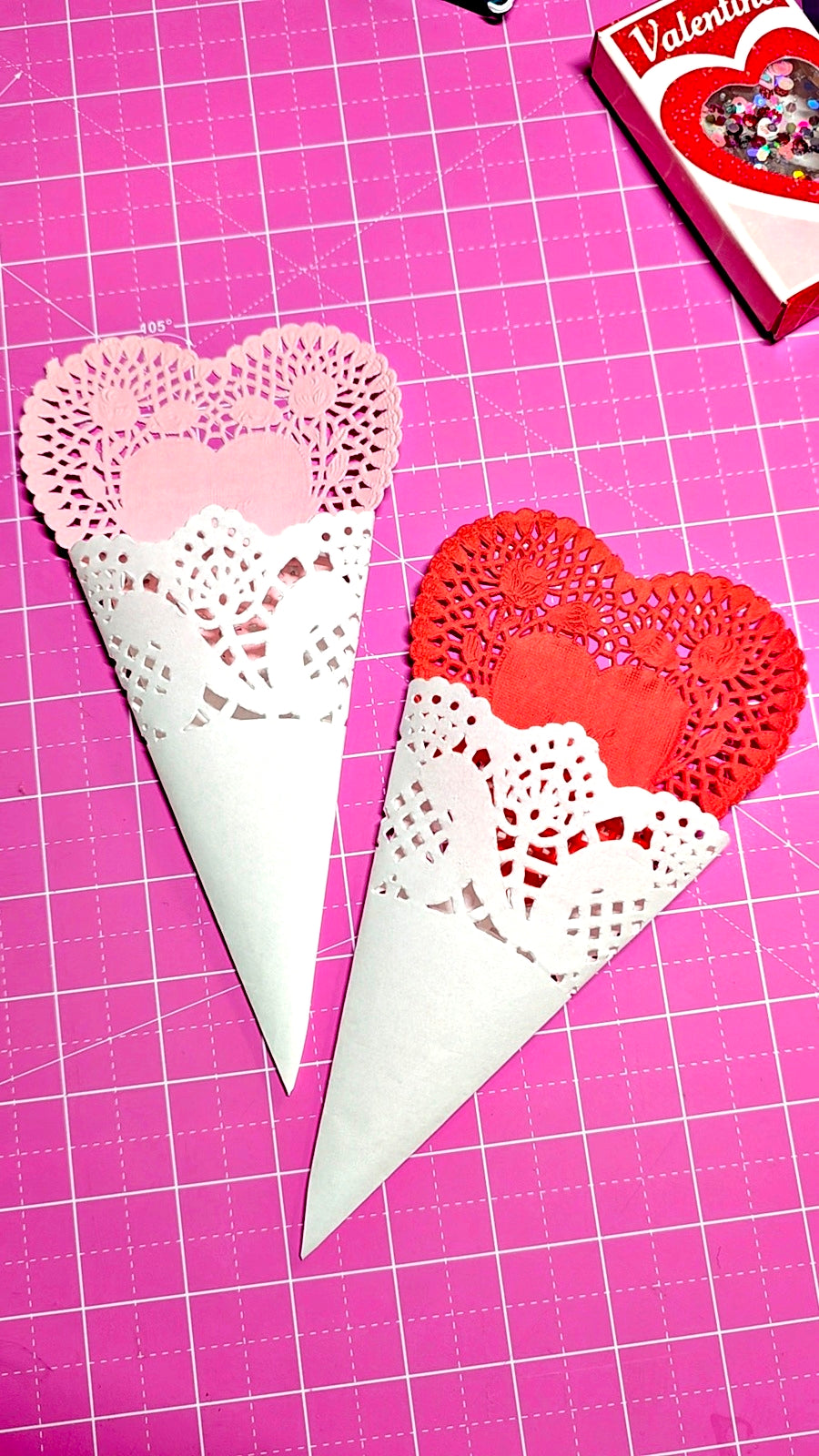 Heart-shaped cones with doily bases on a pink grid background