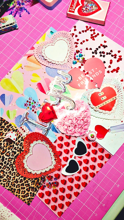 Valentine's Day-themed stationery items on a pink cutting mat with grid lines.