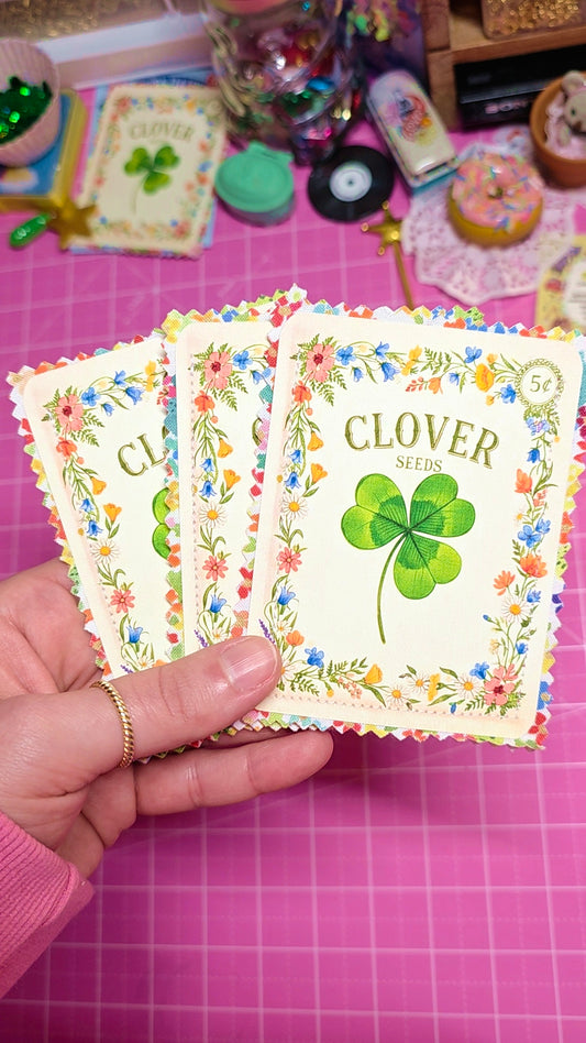 Hand holding a card with a clover design on a pink grid background