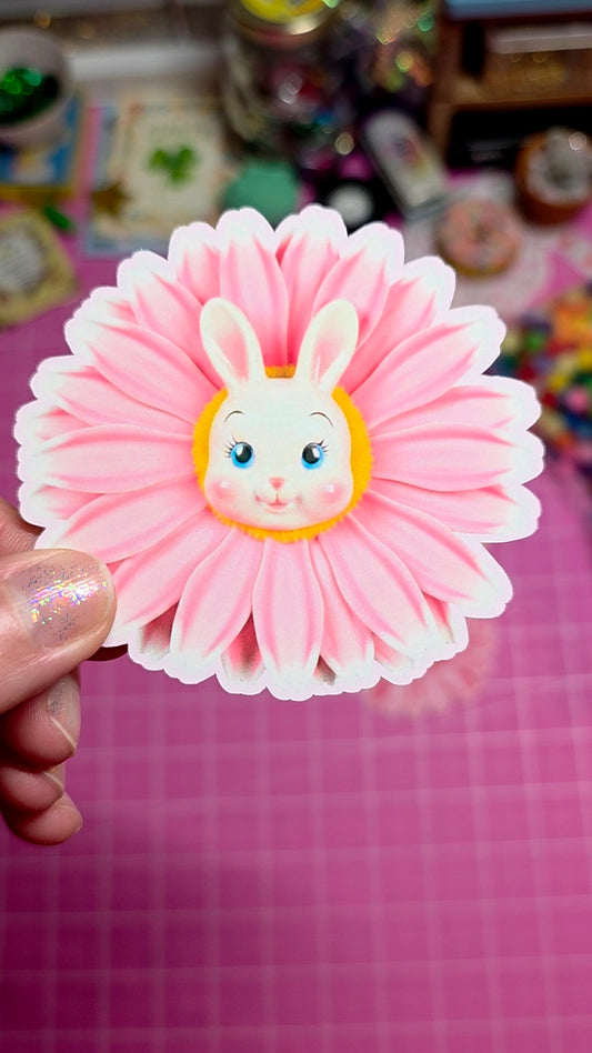Pink flower-shaped hair clip with a cartoon character on a pink background