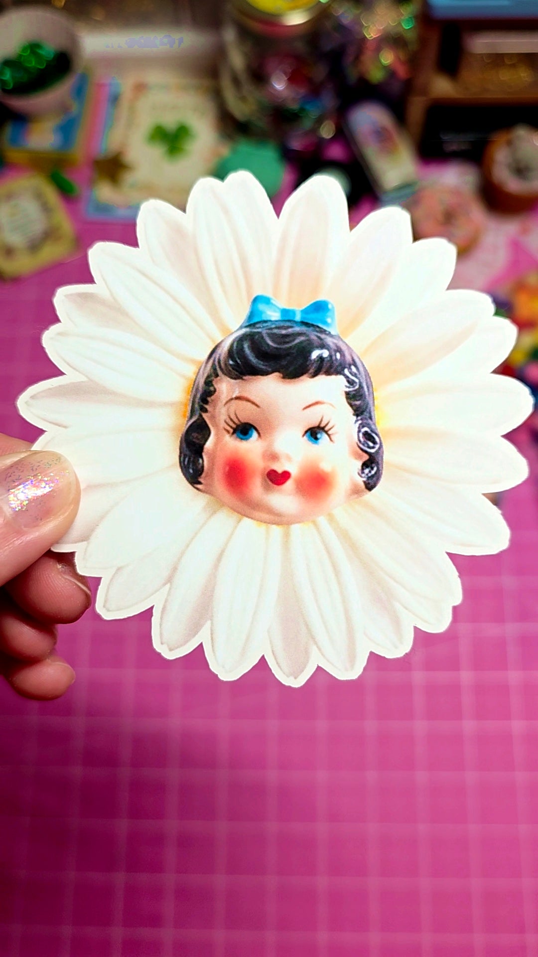 Decorative item with a face design on a white flower-like background
