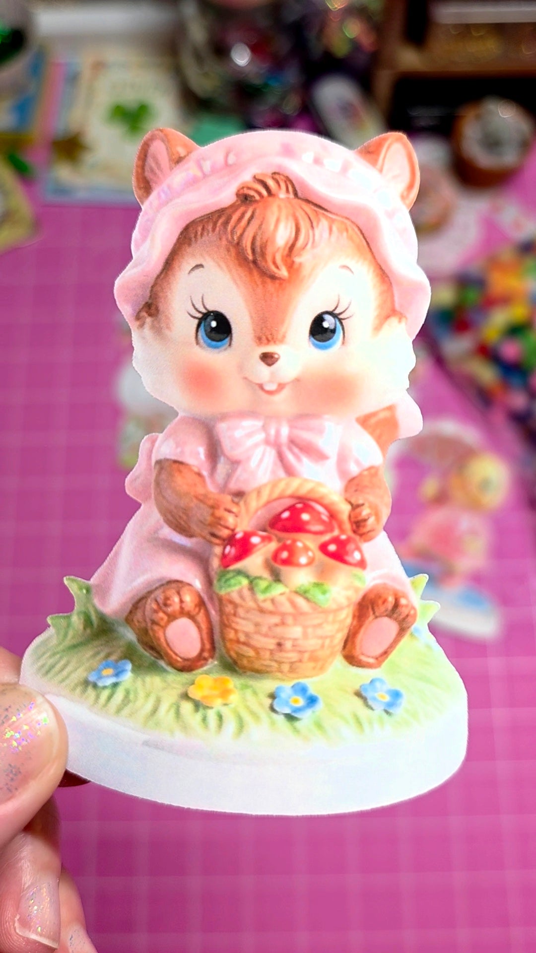 Animated character figurine of a girl squirrel with a basket on a pink background