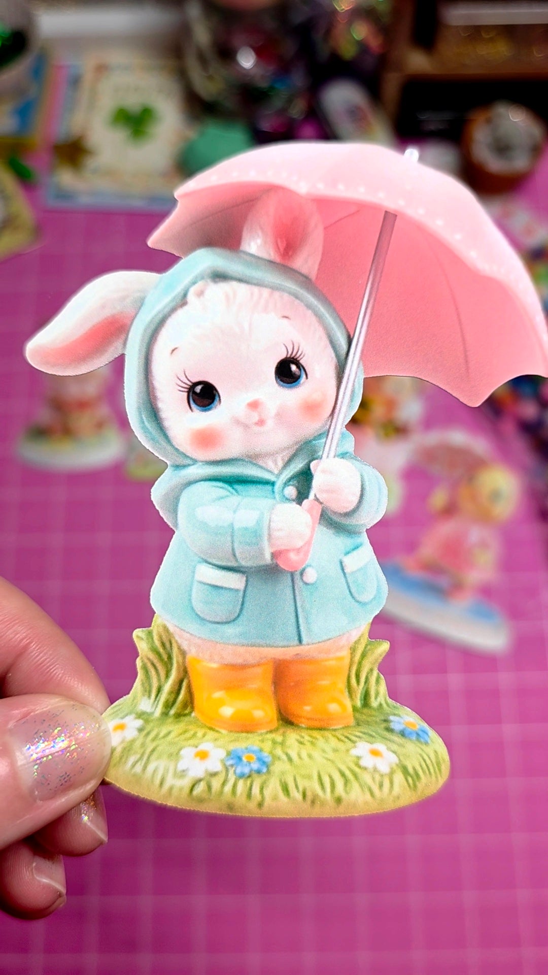 Figurine of a rabbit holding a pink umbrella with a blurred background