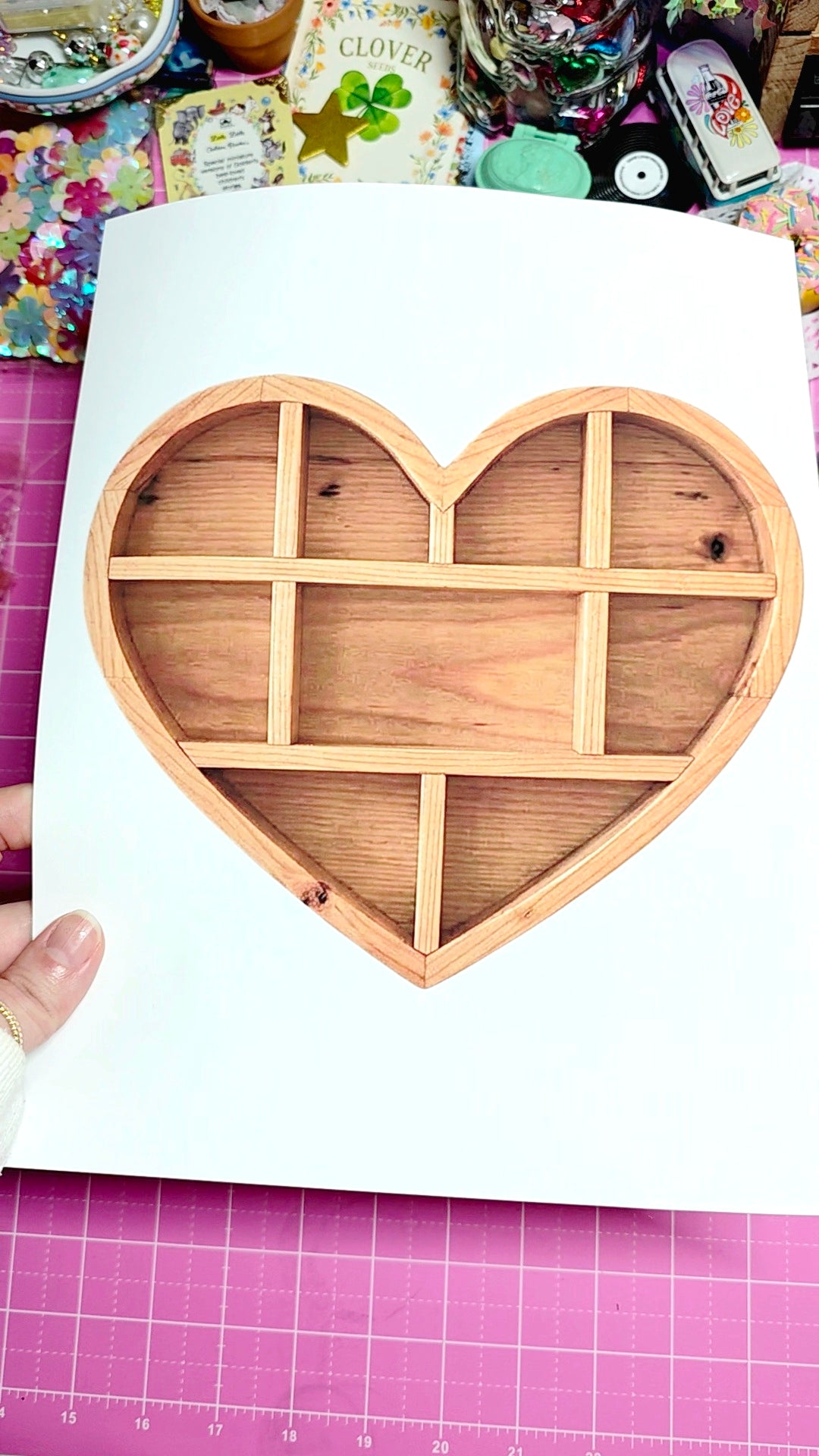 Wooden heart-shaped plate with compartments on a white sheet of paper.