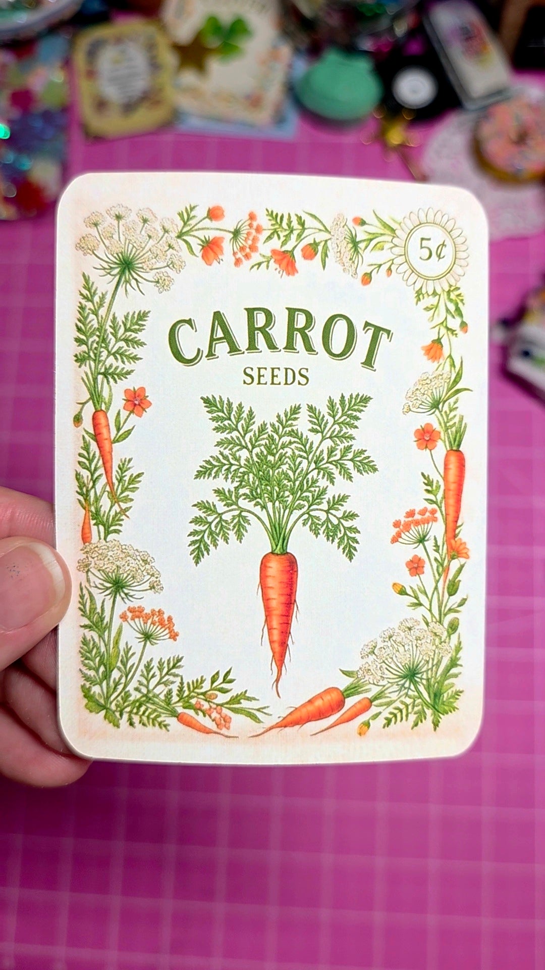 Card with carrot seeds illustration on a pink background