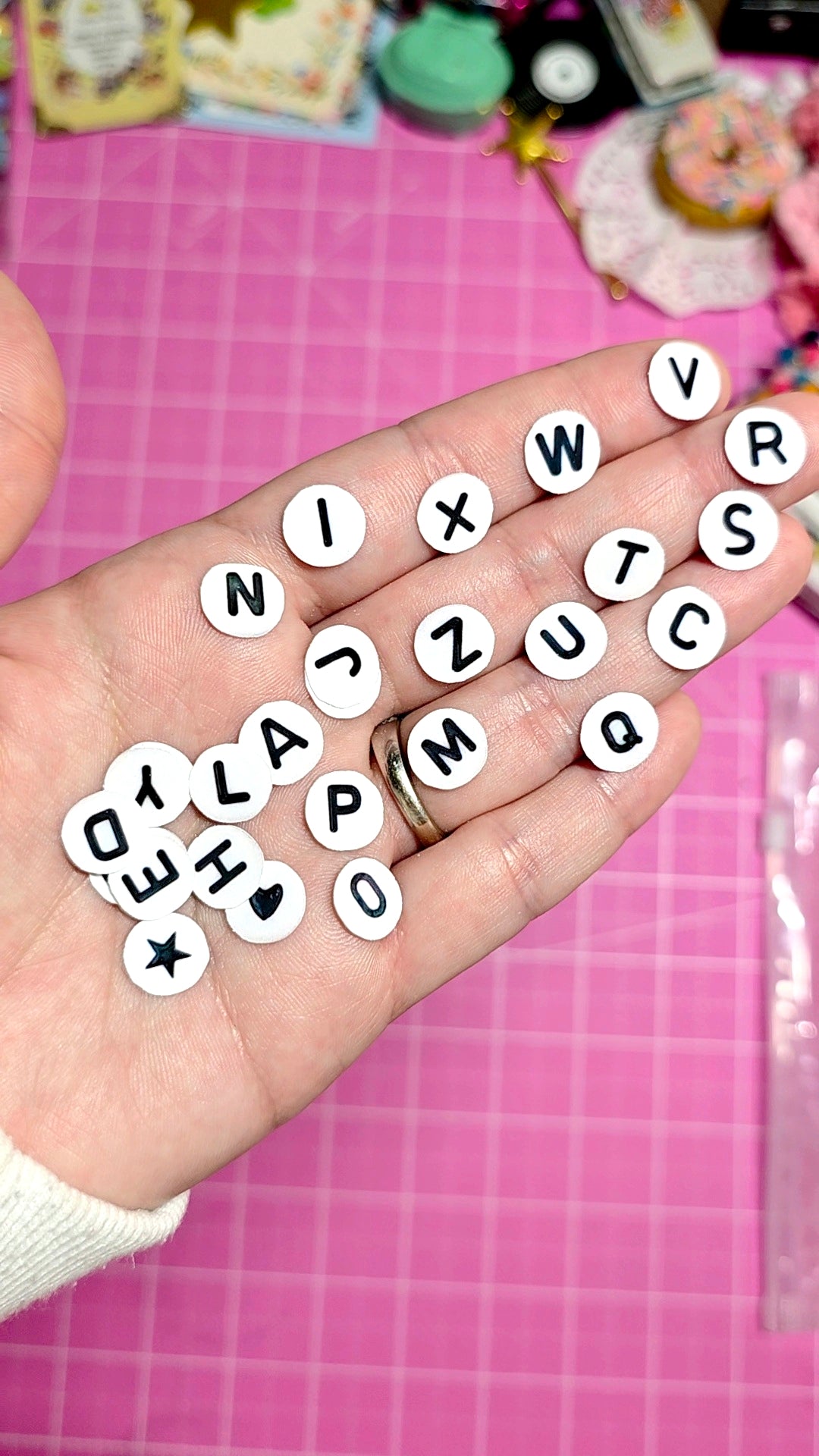 Hand with alphabet letters on a pink grid background