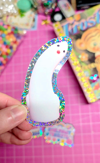 Decorative item with a white center and multicolored border held by a hand on a pink background.