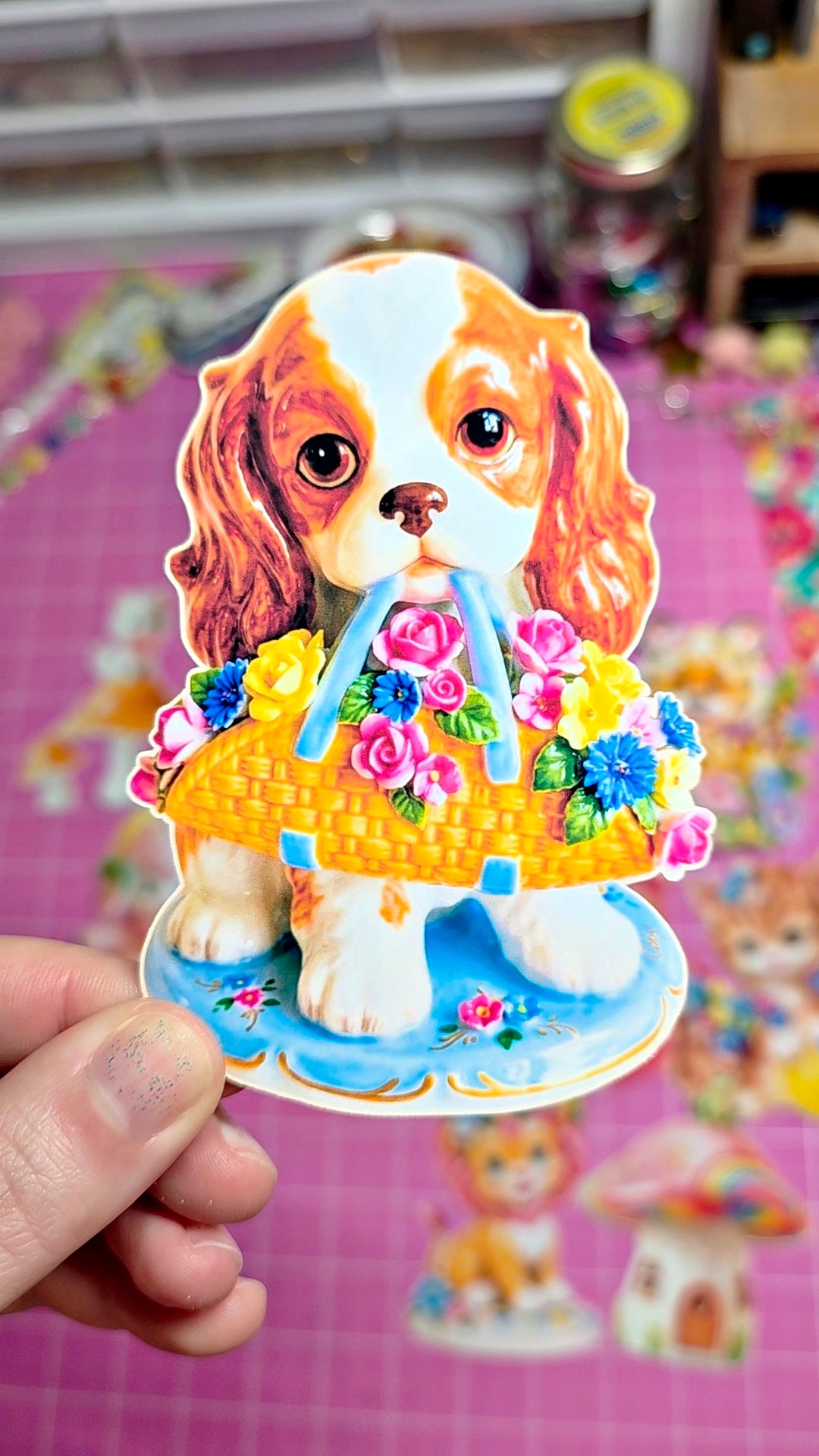 Sticker of a dog with flowers and candles held by a hand on a colorful background