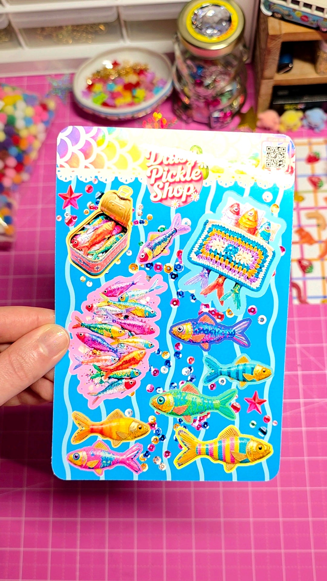 Colorful sticker book with fish designs on a pink surface
