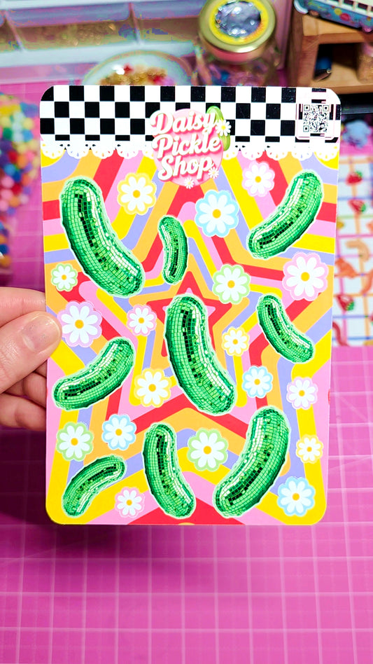 Colorful card with green pickle illustrations and floral patterns on a checkered background