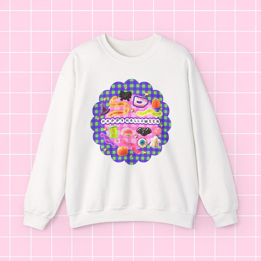A white crewneck sweatshirt featuring a colorful retro graphic with the text 'HAPPY BIRTHDAY' on a pink and green plaid scalloped background, displayed on a pink grid backdrop.