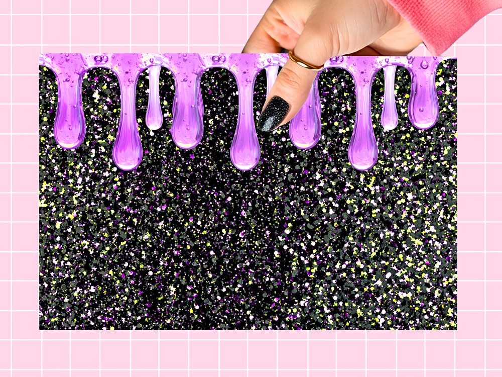 A rectangular black glitter backdrop with purple glittery drip accents along the top, held by a hand with black glitter nail polish against a pink grid background.