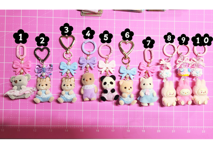 Row of small animal keychains with numbers on a pink grid background
