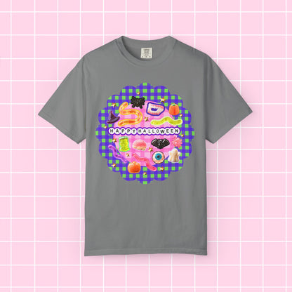 A gray short-sleeve crewneck t-shirt featuring a colorful 'Happy Halloween' graphic print on the front, displayed against a pink grid background.