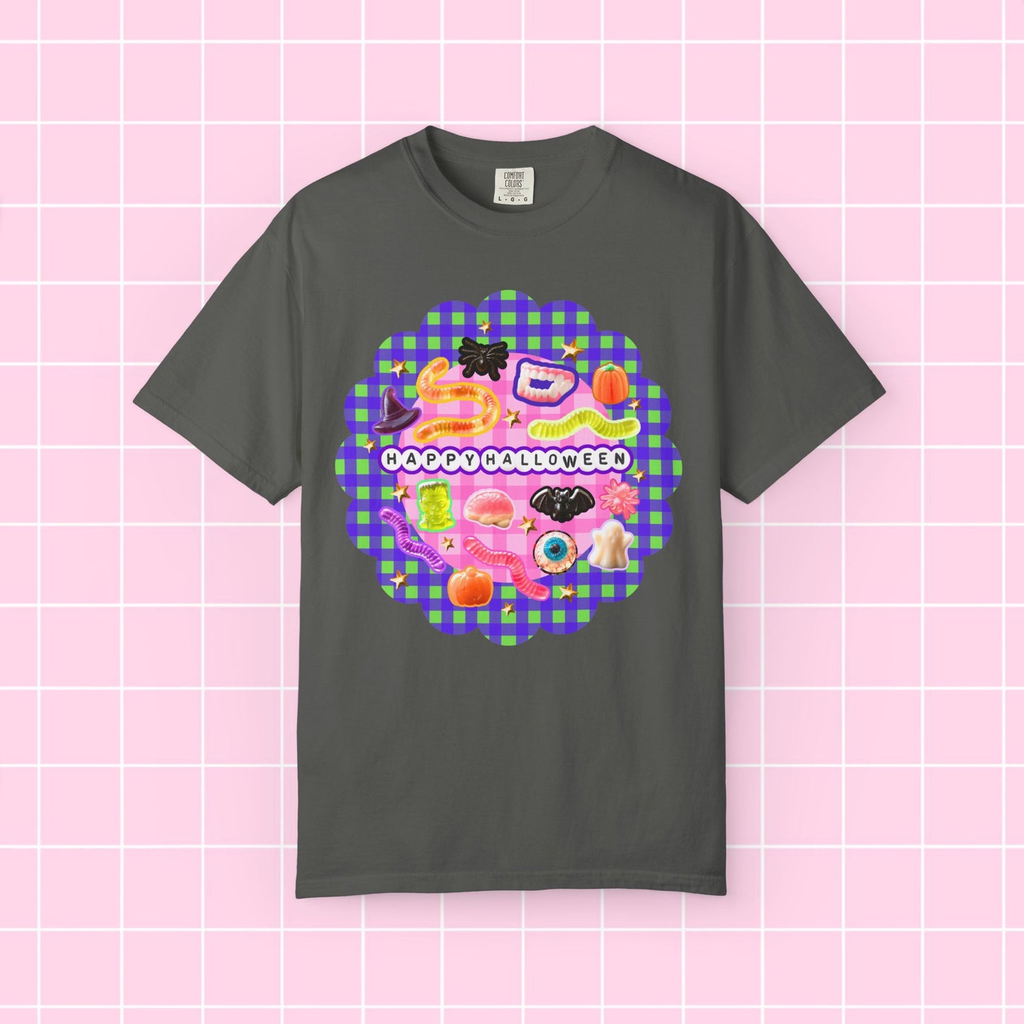 A gray short-sleeve crewneck t-shirt featuring a colorful 'Happy Halloween' graphic print on the front, displayed against a pink grid background.