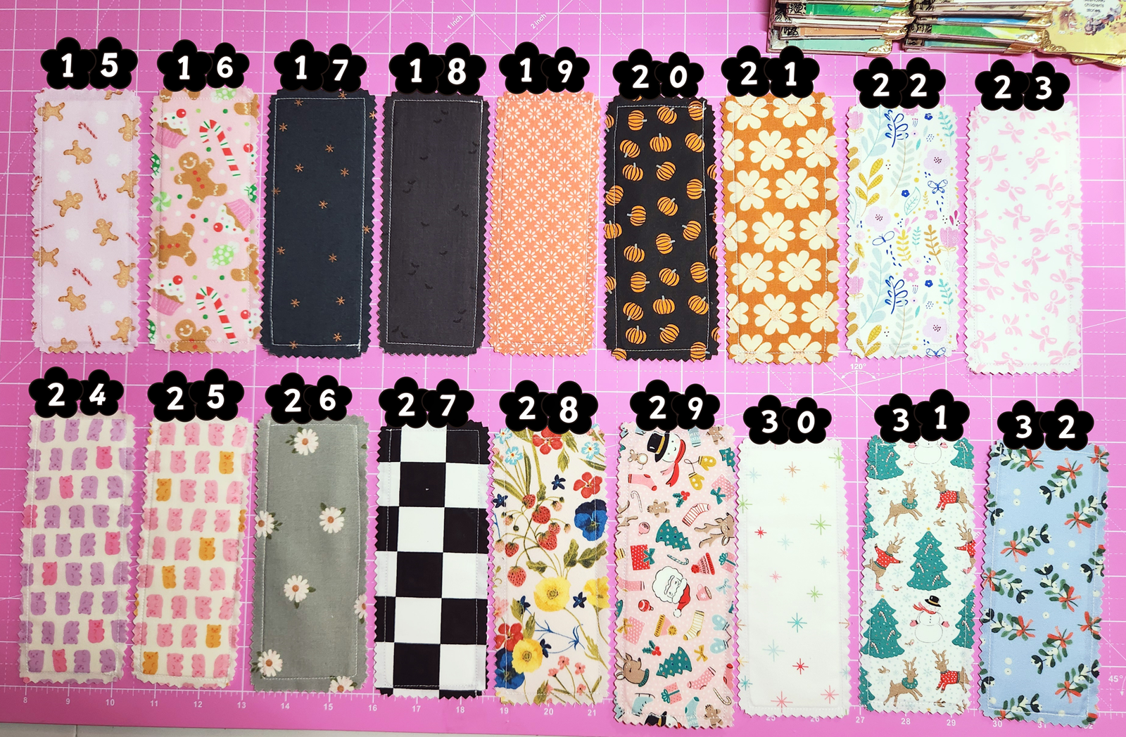 Collection of fabric swatches with various patterns on a pink cutting mat.