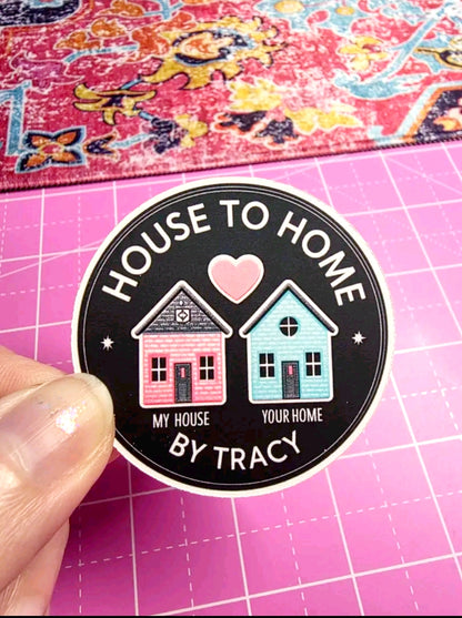 Sticker with 'House to Home' design held over a pink cutting mat.