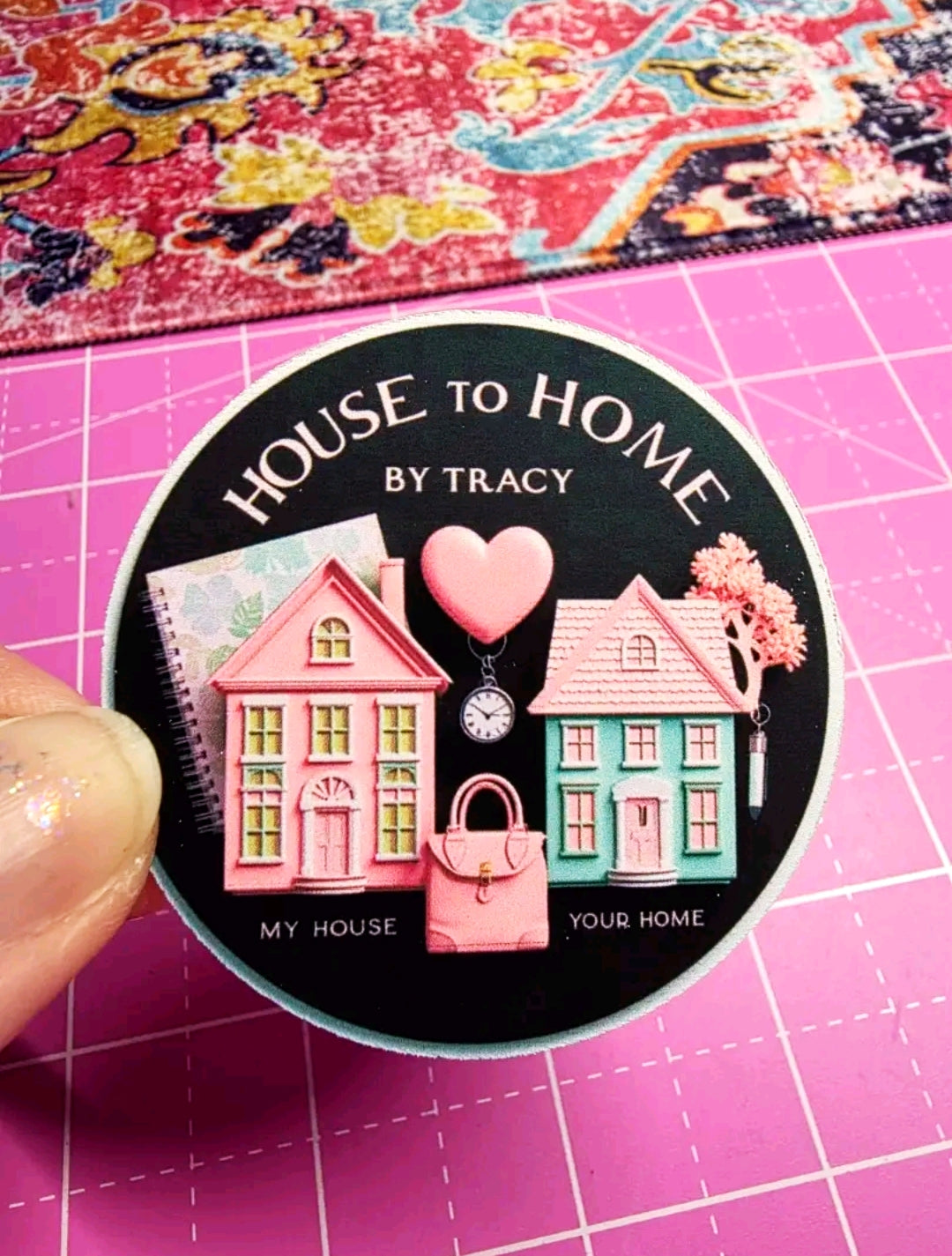 Sticker with 'House to Home by Tracy' design on a pink cutting mat.