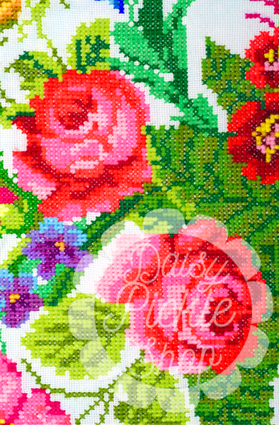Floral pattern with 'Daisy White' text on a cross-stitch or embroidery design.