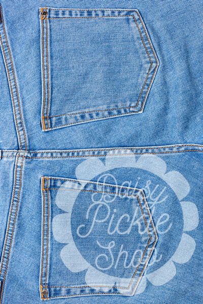 Close-up of blue denim fabric with a floral design and text.