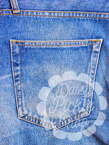 Close-up of a blue denim pocket with a brand logo.