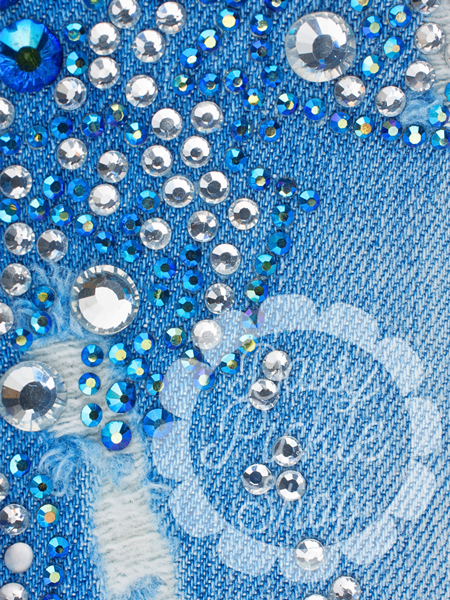 Close-up of a blue fabric surface with embedded rhinestones and sequins.
