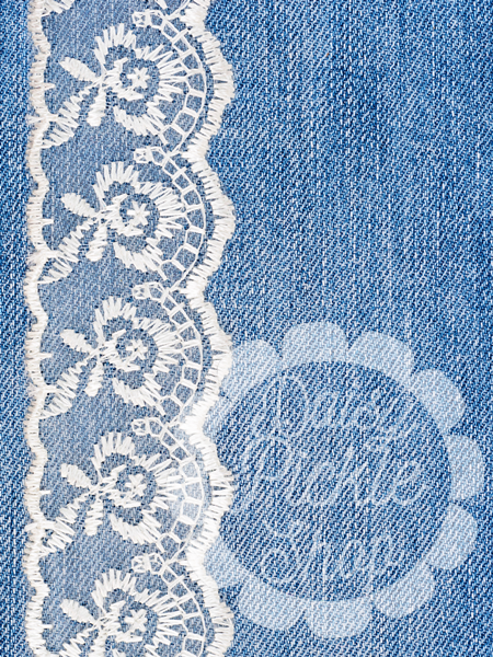 Blue denim fabric with white lace trim and embroidered text.