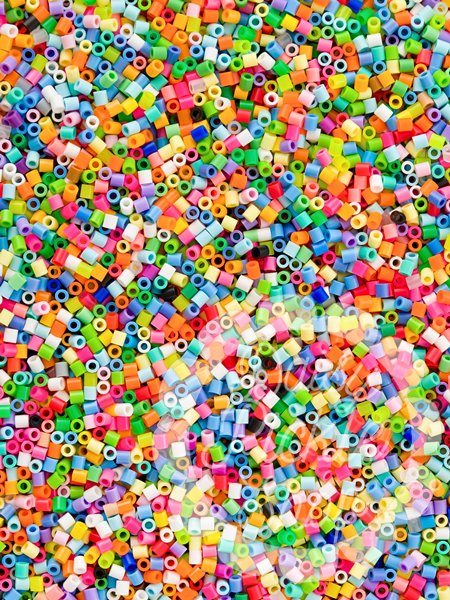 Colorful plastic beads scattered on a multicolored background