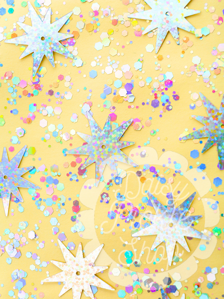 Colorful confetti and star-shaped decorations on a yellow background