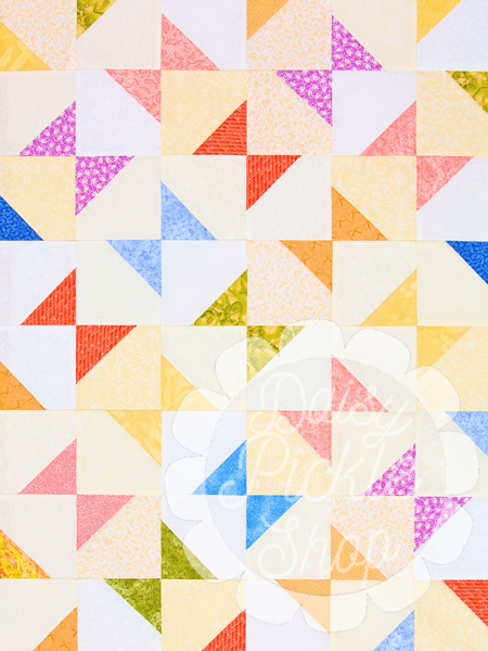 Colorful quilt with geometric pattern on a grassy background