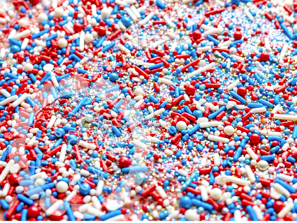 Colorful sprinkles in red, white, and blue on a white background
